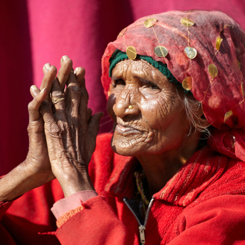 Intilainen punaisiin pukeutunut vanha nainen.